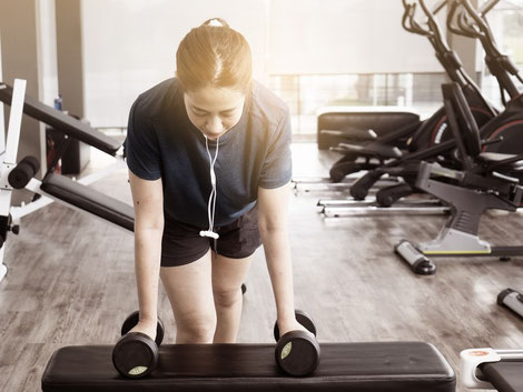 Asian woman at the gym lifting weights