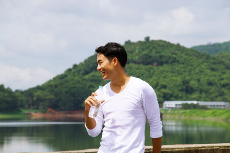 A healthy asian man drinking good quality water to maintain a healthy lifestyle