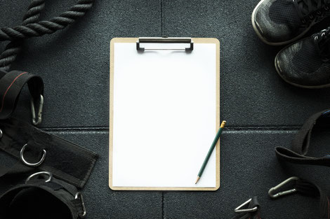 Clipboard check list in Gym with fitness sport equipment background