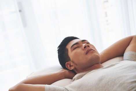 Asian young man sleeping on his bed in the morning