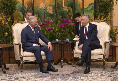 Prince Charles and PM Lee having afternoon tea in an room with oriental furnishings