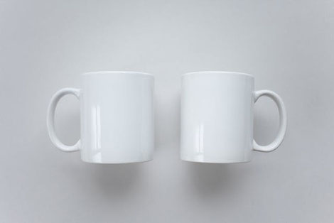 コンサル面談中の様子。コーヒーカップと手帳。傍らにクローバーが活けられた水差し。