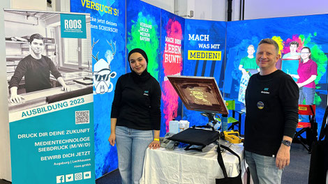 Christian Roos and apprentice media technologist screen printing at fitforJob! Trade Fair in Augsburg 