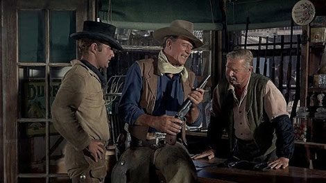 The artist who created the paintings for the "El Dorado" title sequence makes an appearence with John Wayne: Olaf Wieghorst.