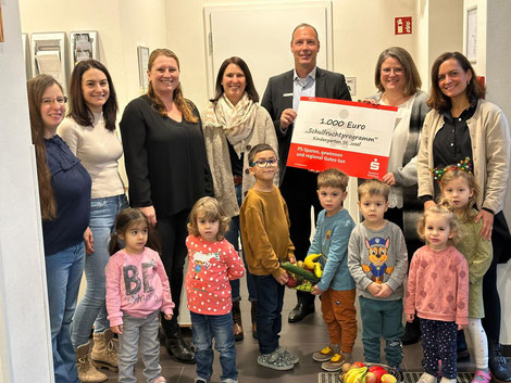 v.l.n.r.: Nadine Klein, Christine Reiß, Rebecca Opluschtil, Stephanie Greulich (alle Förderverein), Herr Lott (Regionalleiter Angelbachtal Sparkasse HD), Michaela Beigel (Kindergartenleiterin) und Frau Martin (Serviceberaterin Sparkasse HD) sowie Kinder 