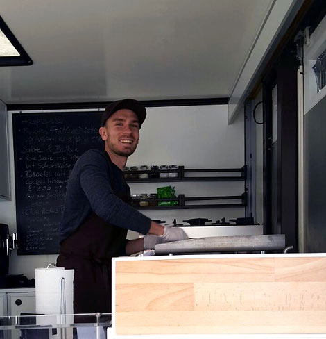 Grüner Sepp lachend in seinem Food Truck
