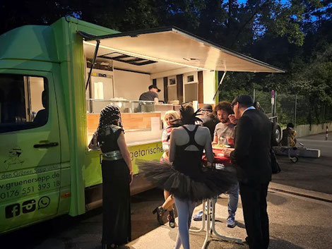 Gäste essen entspannt am Food Truck – kein klassisches Buffet, sondern laufende Ausgabe