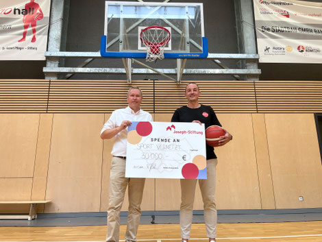 Markus Jakob, Vorstand der Joseph-Stiftung, übergibt den Spendenscheck in Höhe von 30 000 Euro an Bamberg-Baskets-Markenbotschafter und zweiten Vorsitzenden von Freak City e.V., Karsten Tadda. Foto: Benjamin Kemmer