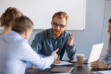 Eine Diskussion am Besprechungstisch als Ausdruck für Konfliktpotential