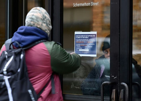  Un homme devant le département du Travail à New York le 25 mars 2020