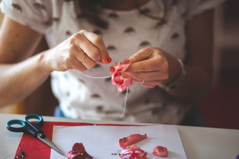 Confection artisanale d'une couronne de fleurs en tissus et papiers pour un mariage thème Japon en rose, rouge et blanc par La mariée en fleur. Crédit photo: Sophie Bachère