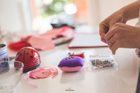 Confection artisanale d'une couronne de fleurs en tissus et papiers pour un mariage thème Japon en rose, rouge et blanc par La mariée en fleur. Crédit photo: Sophie Bachère
