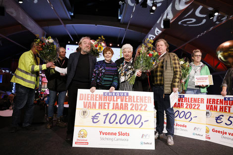Yvonne Slots, de oprichtster van carnivora neemt een cheque van €10,000,- in ontvangst omdat ze verkozen is tot dierenhulpverlener van het jaar 2022. Ook op de foto: bekende dierenarts Piet Hellemans, Lenie 't hart, de directeurs van stichting dierenlot
