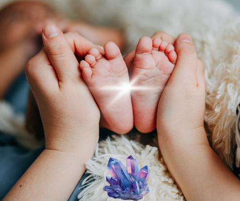 Babyfüße werden von 2 Heilenden Händen während einer Heilsitzung gehalten
