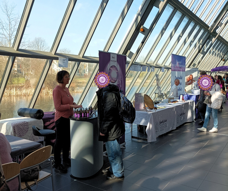 Geistheilerin Ina Paulus berät einen Messebesucher auf der Wohlfühlmesse an ihrem Messestand
