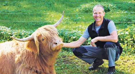 Das Schottische Hochlandrind geniesst die Zuwendung von Christian Klaus. Bild Otto Graf