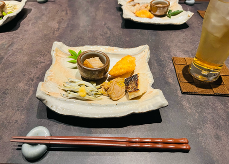 和ダイニングNOWEREにて全祭の盛り合わせにはきびなごや鮭の南蛮漬け、西京焼き、鶏肉のカレー煮、魚のフライが四角い大皿に乗っています