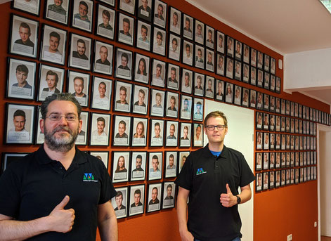 Nehat Helber (l.) und Christoph Schaaf vor der „Wall of fame“ mit Fotos erfolgreicher Absolventen der Berufsförderung I Foto: Werkkiste