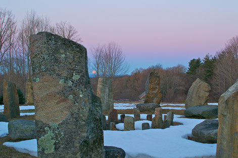 The moon setting behind the stone circle at Distant Hill Gardens.