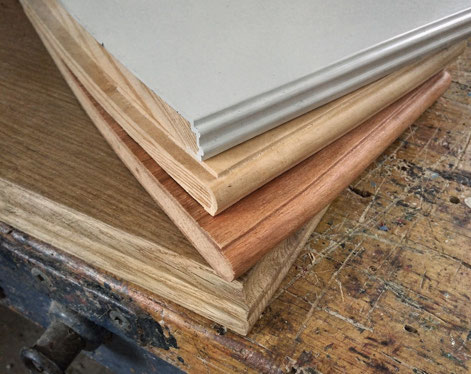 Auf einer alten Hobelbank liegen Holzfensterbänke mit unterschiedlichen Profilen, Holzarten und Oberflächenbehandlungen