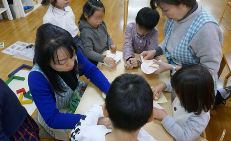 幼稚園児クラスでは、格子編みや二つ折りの切り紙、ハートバッグなどクリスマスグッズの製作にみんなで取り組んでいます。