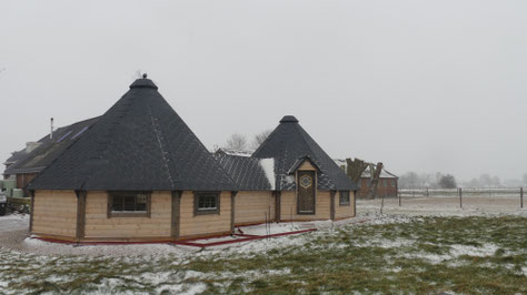 with a roof, a little snow and view of the riding arena