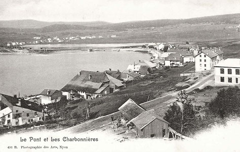 La scierie Mouquin au début du XXe siècle. A droite le bâtiment de la Lustrerie. Plus loin les deux corps de bâtiment qui constitueront l’Hôtel Mon Désir. Au bord du lac, sous-jacente, la maison du Grand-Toit