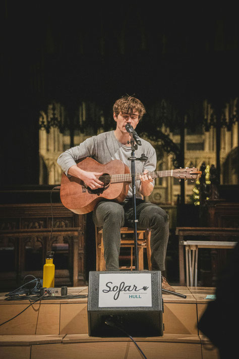 Mann singt und spielt Gitarre beim Gesangsunterricht in München Schwabing