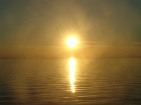 Aus dem dunkeln eines Burnouts oder einer Depression heraustreten. Licht in sein Leben lassen, wie diese aufgehende Sonne über dem Meer.