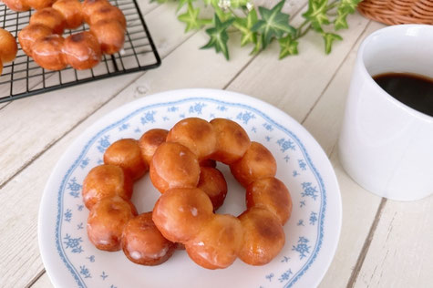 ピンクのノートパソコン、紅茶の入ったカップ&ソーサ。ピンクのバラとガーベラ。