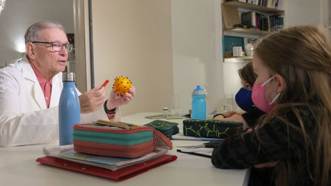 Dr. Ludwig Kaspar erklärt ein Coronavirus-Modell