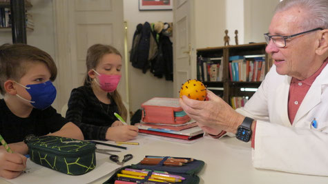 Arzt erklärt Schulkindern das Coronavirus
