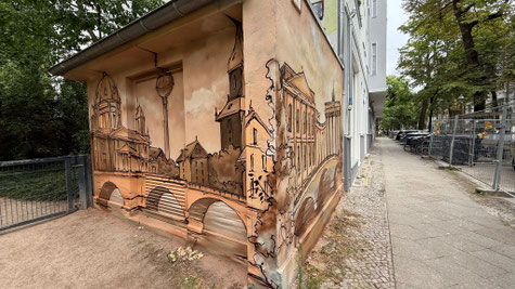 Sieht aus wie Papier, ist aber Beton: Mit speziellen Sprüh- und Maltechniken imitieren wir den Look einer alten Zeichnung direkt auf der rauen Fassade.