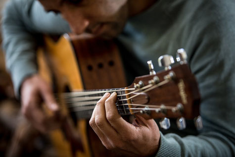 Mann spielt im Gitarrenunterricht in München Maxvorstadt
