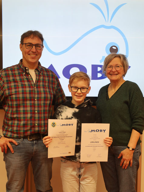 Jürgen Christ, und Claudia Dahl, stellvertretende Schulleiterin, gratulierten Lasse Geiger zu seinem erfolgreichen Abschneiden bei der Bayerischen Mathematikolympiade und überreichten ihm zur Anerkennung die offiziellen Urkunden.