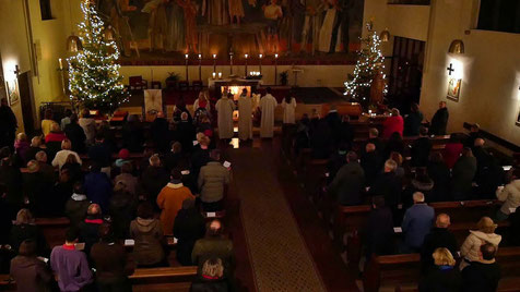 Am Ende der Christmette wird das Licht ausgemacht und gemeinsam singen alle "Stille Nacht, Heilige Nacht", Foto von der Christmette am 24.Dezember 2024.