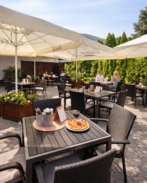 Auf unserer sonnigen Terrasse genießen Sie Pizza, Pasta, italienischen Wein oder einen cremigen Espresso in entspannter Atmosphäre.