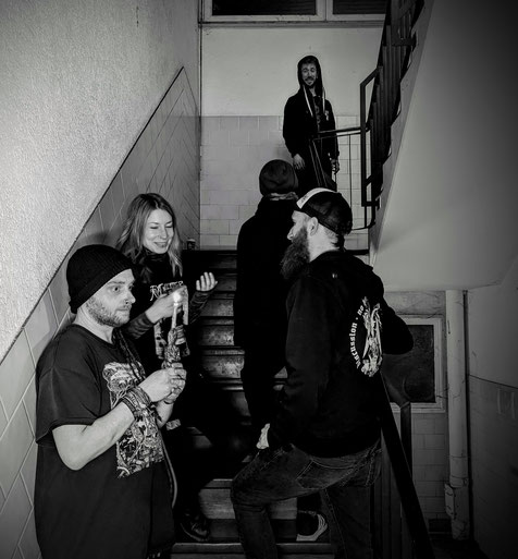 Die Band in einem Treppenhaus auf einem Schwarz-Weiß-Foto