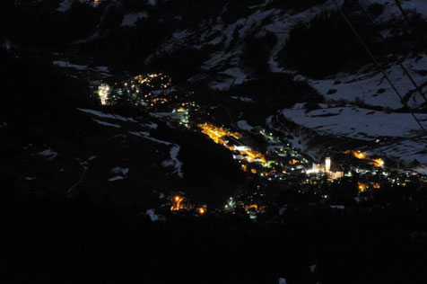 Der Ort Disentis/Mustér in der Cadi, Surselva, Graubünden, Schweiz in Winterstimmung und Schnee in einer Vollmondnacht. Foto: Stefan Schwenke