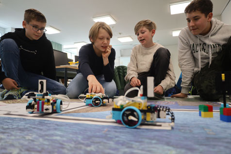 Felix Büringer, Emil Hildebrand, Sebastian Schmid und Artem Geier (v.l.n.r) programmieren in der Robotik-AG des THG Nördlingen schon die fortgeschrittenen Roboter und testen, ob ihre Roboter die entsprechenden Wege auf der Spielfeldmatte zurücklegen.