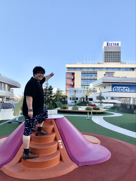 「万代シティ」屋上公園遊具に登って、伊勢丹デパートを指差すYUTAKA