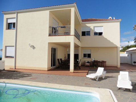 Freistehendes 2 stöckiges Einfamilienhaus mit Pool davor.