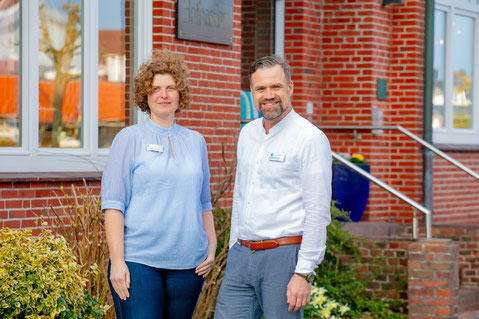 Silke Duken, die stellvertretende Hoteldirektorin, und Marc Deffland, der Hoteldirektor, stehen vor dem Haupteingang des Hotels.