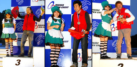 レースクイーンといっしょに喜びを噛みしめる各ライダーたち。左から3位/橋川選手、1位/新垣(急用で表彰式を欠席した新垣選手に替わり、壇上には代理の関根さんが登った)、2位/庭田選手