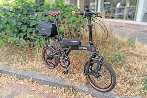 Birdy City – Mit optionalem Gepäckträger und Ortlieb Trunk-Bag, auf dem Rahmen befestigt eine Hülle für das gefaltete Birdy, dazu ein Ledersattel und Korkgriffe.