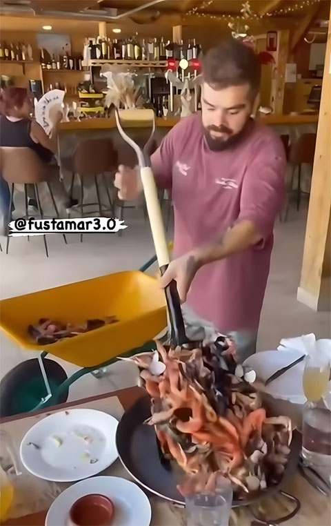 sirviendo una gran mariscada a un cliente