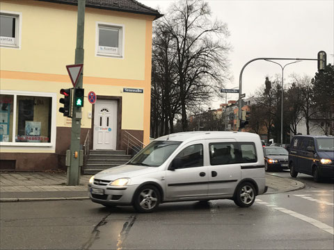 O sinal está verde para pedestres, mas é o carro que passa.