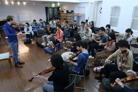 Oisin MacDiarmada teaching the fiddle at a workshop in Tokyo