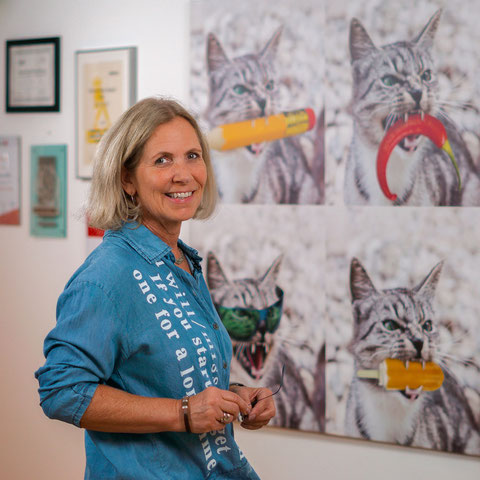 Portrait von Andrea Kurz (Firma Kurzdesign) in ihrem Atelier in Perchtoldsdorf vor dem vierteiligen Katzenbild
