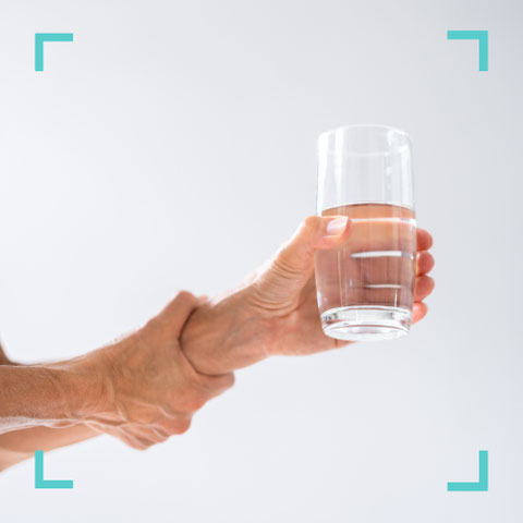 Hand mit Muskelanspannung hält ein Glas Wasser – Behandlung von Spastik in der Praxis Neuro im Zentrum St. Gallen